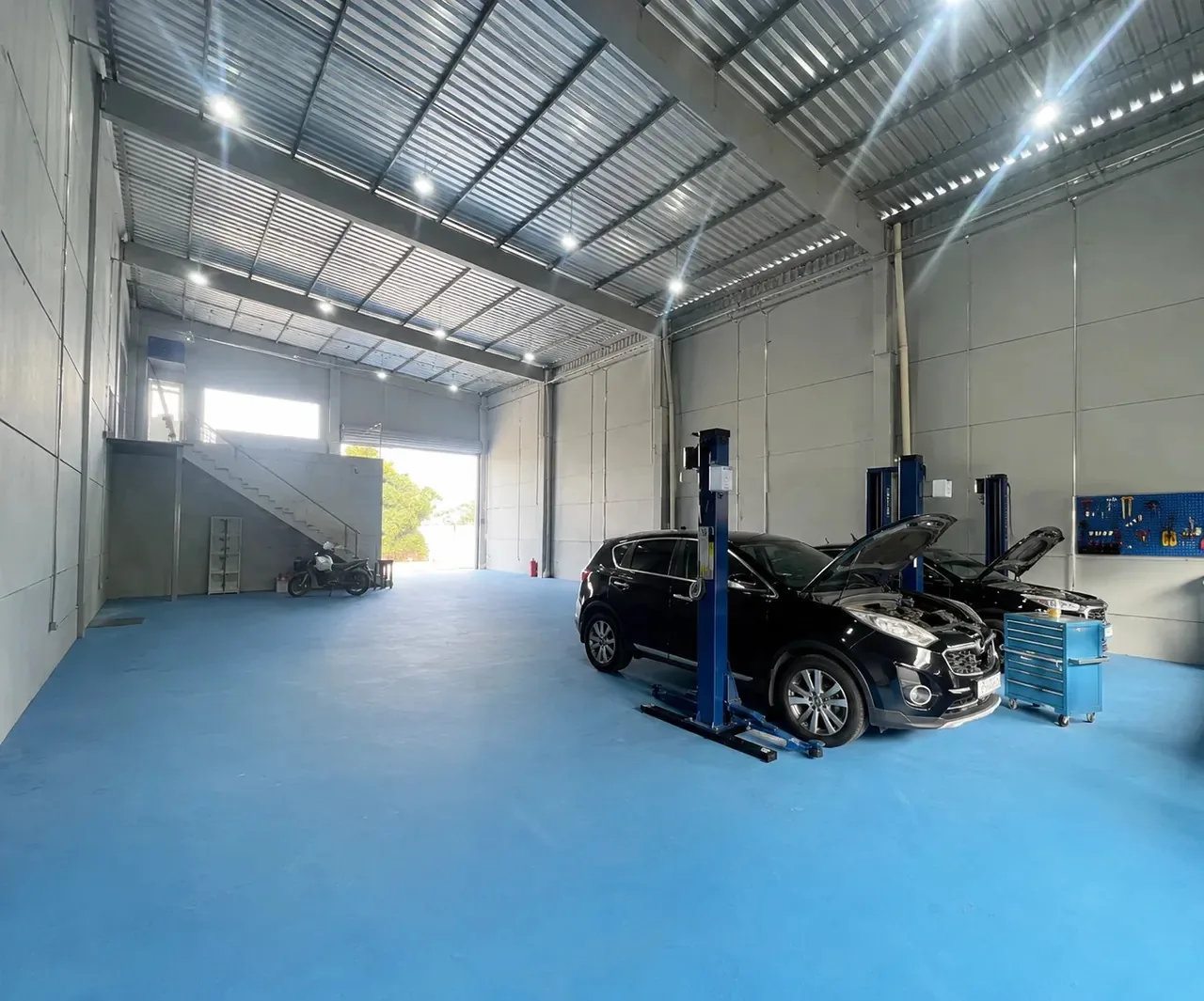 Veículos com o capô aberto sobre elevadores na oficina da Elite Auto Tech